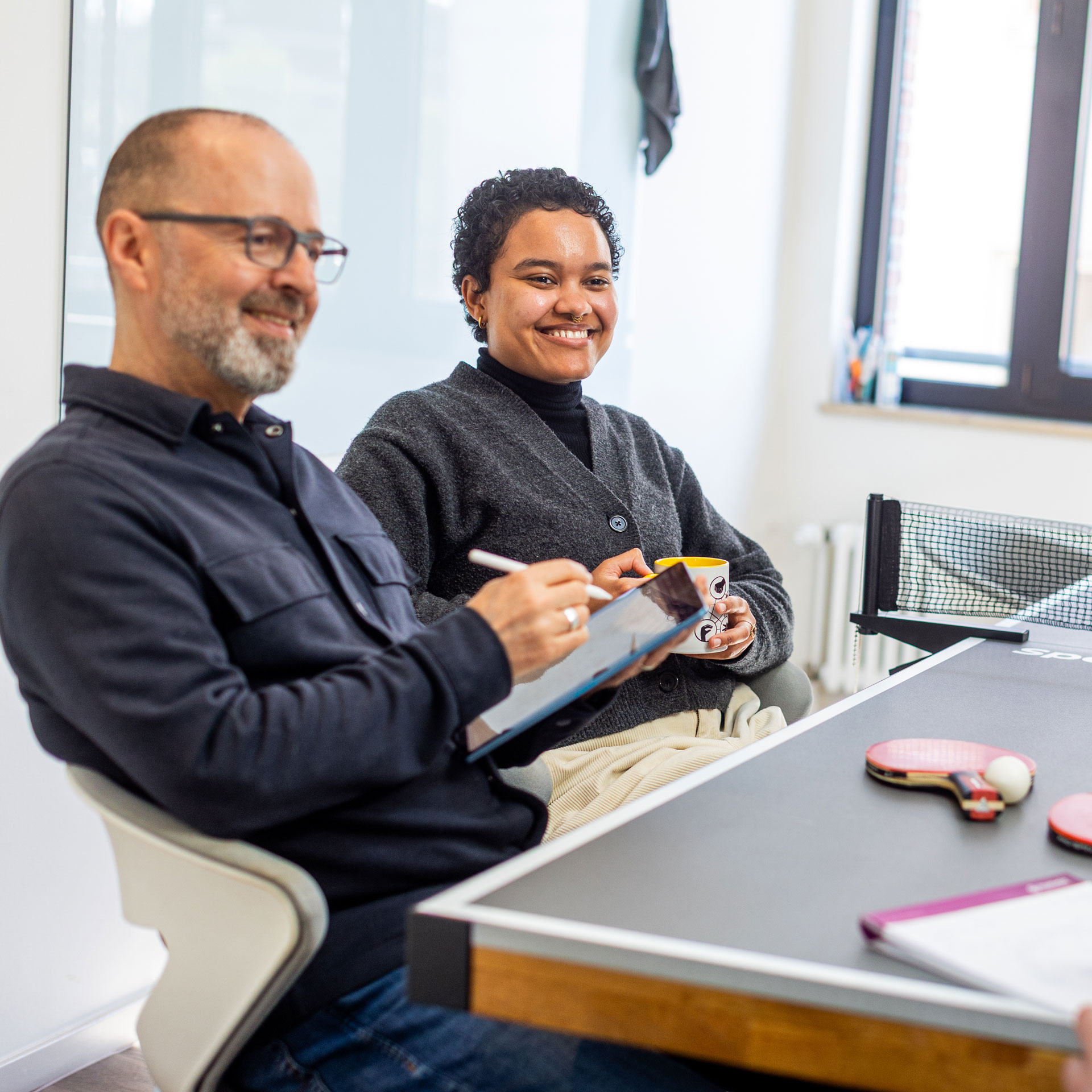 Oli und Sylvie in der Angentur an der Tischtennisplatte in einem Kreativ-Meeting